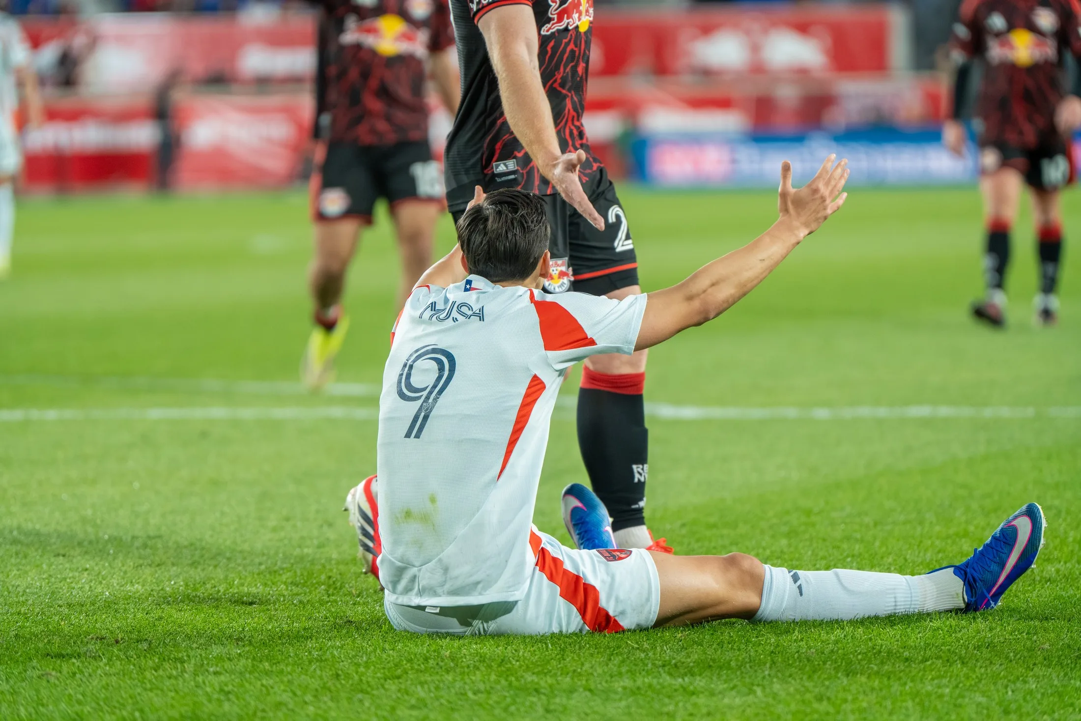 Petar Musa, de blanco, sentado en el césped durante un partido del FC Dallas en mayo de 2026.